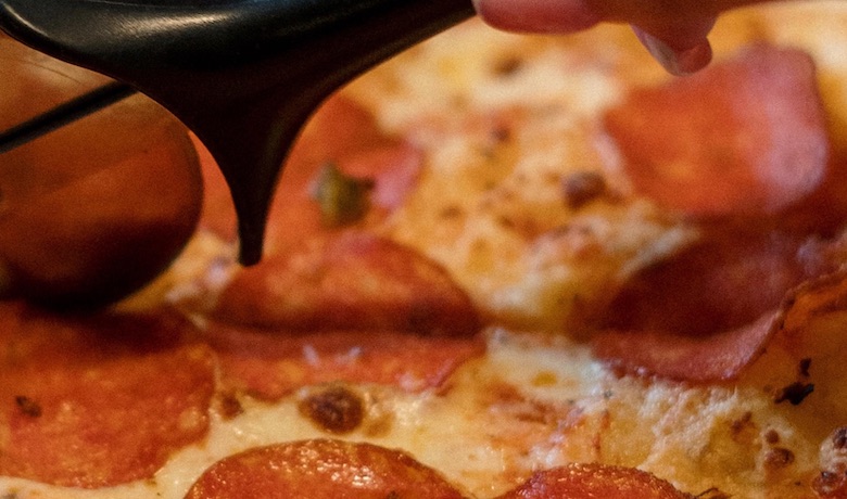 A screenshot of pepperoni pizza being sliced at Pizzeria restaurant in Circus Circus Hotel and Casino Las Vegas.