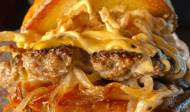 A screenshot of a burger from FukuBurger with a food truck location at the Hawaiian Marketplace in Las Vegas.
